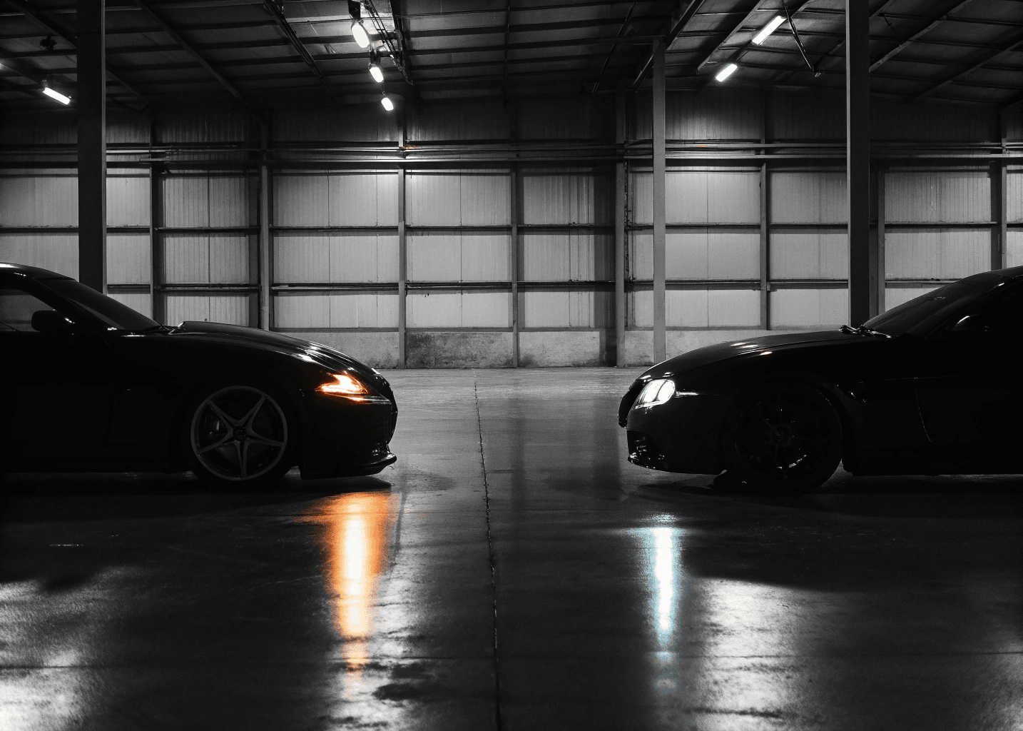 Two performance cars facing each other in a dark warehouse — part exchange service